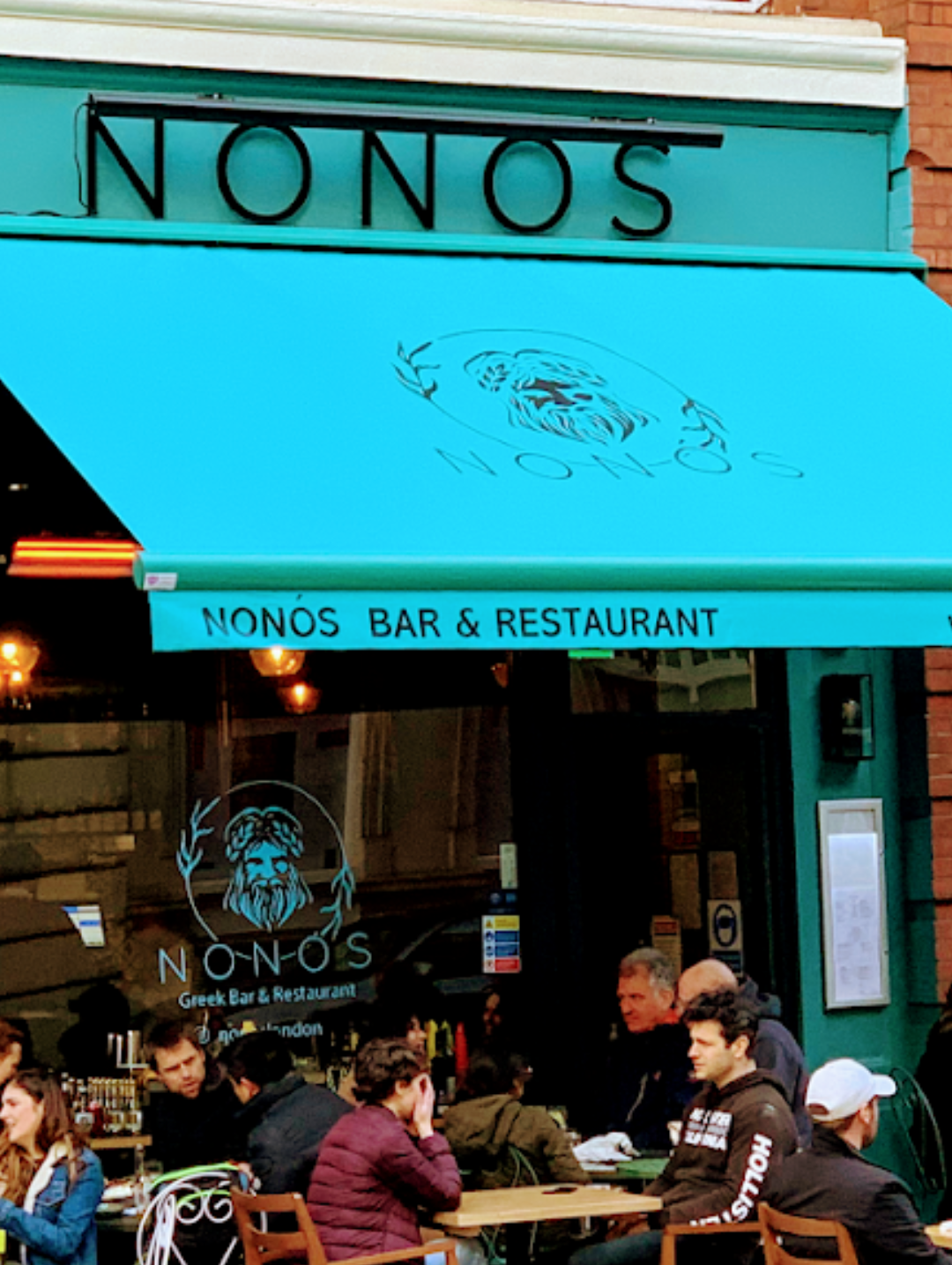 The turquoise Nonòs awning with guests at pavement tables outside