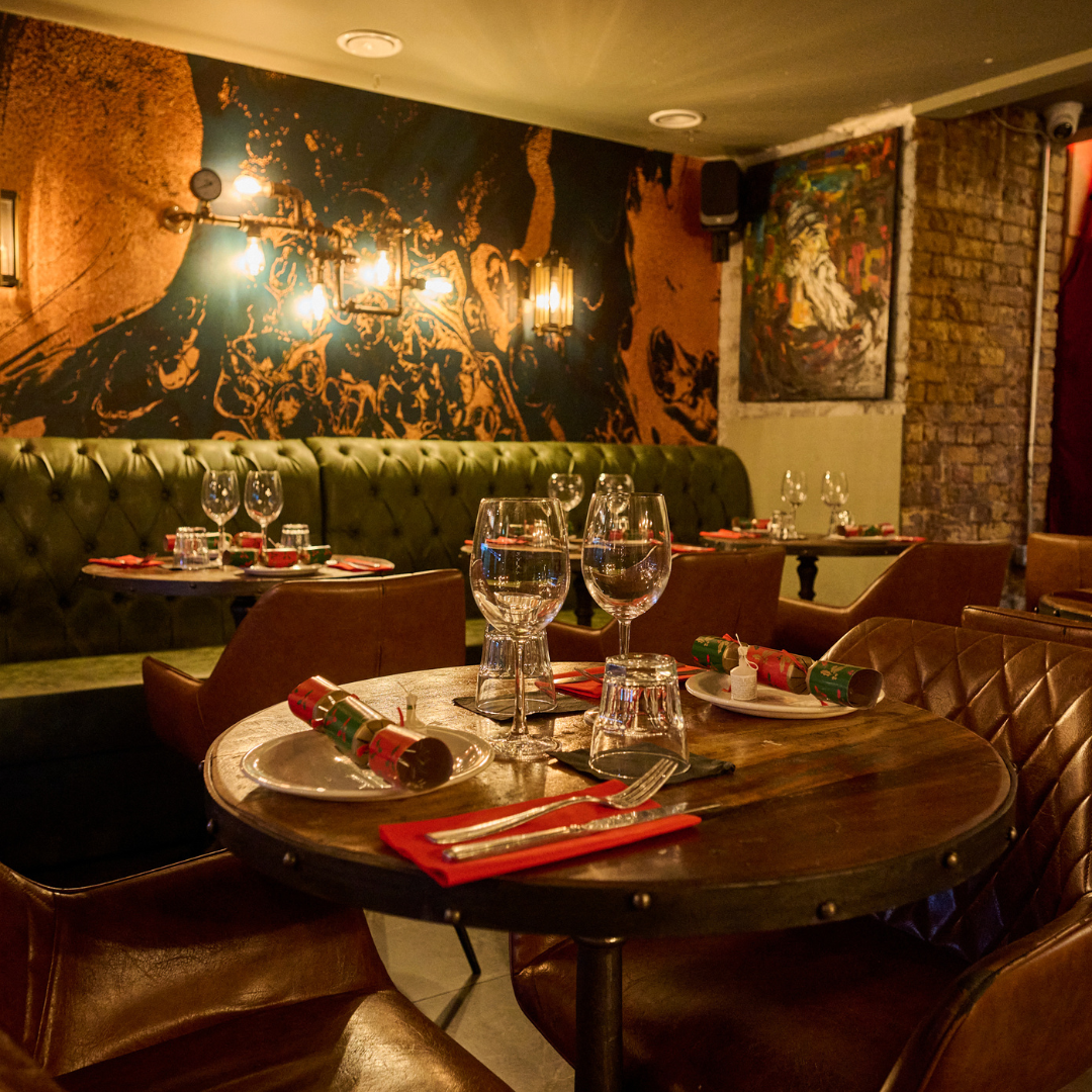 Candlelit dining table set for a group dinner at Nonos