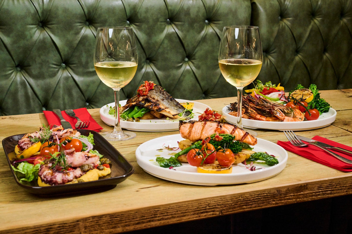 Grilled plates and white wine at Nonòs Judd Street, ready after Greek starters